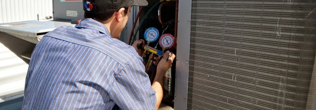 HVAC technician servicing a condenser unit in Wickliffe